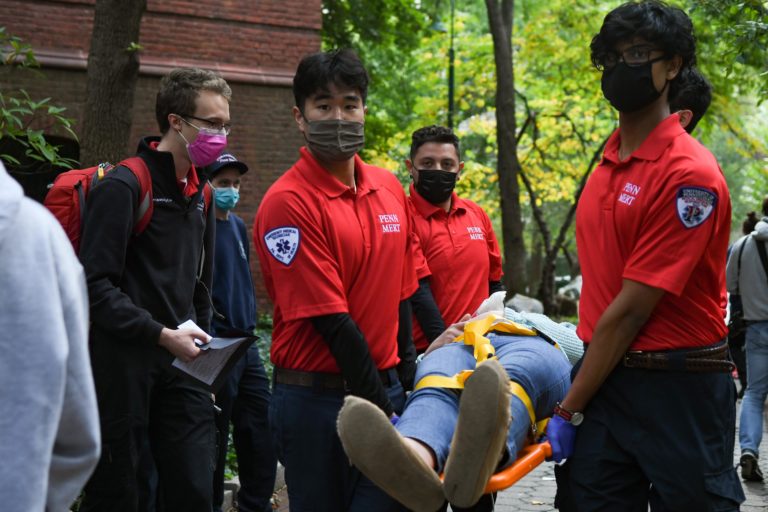 EMTs transport a patient by backboard.